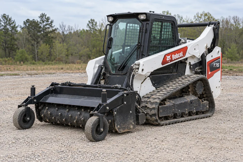 Bobcat T76 compact track loader fitted with a power box rake
