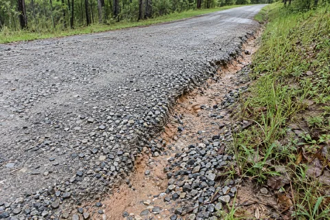 Eroded gravel driveway edge after runoff washed material away